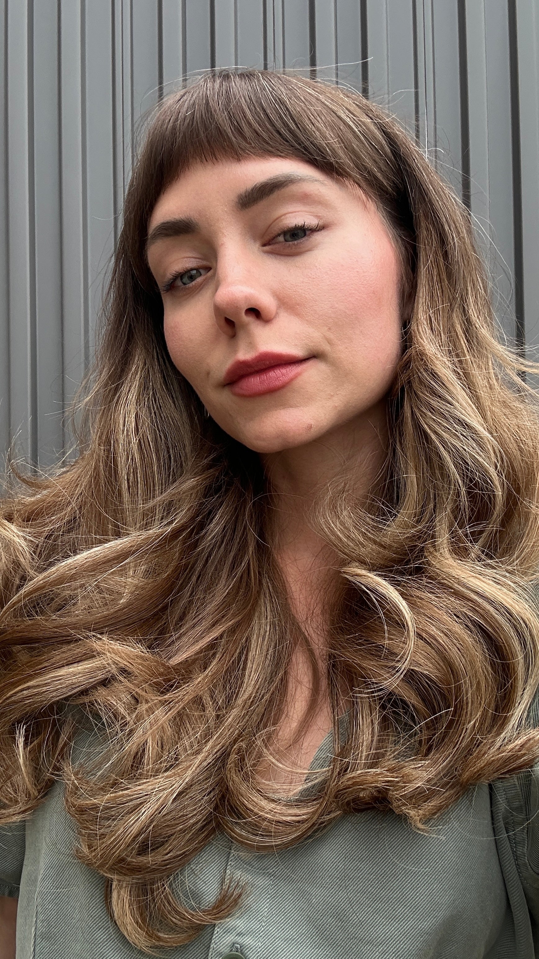 Woman with long wavy hair against a neutral background